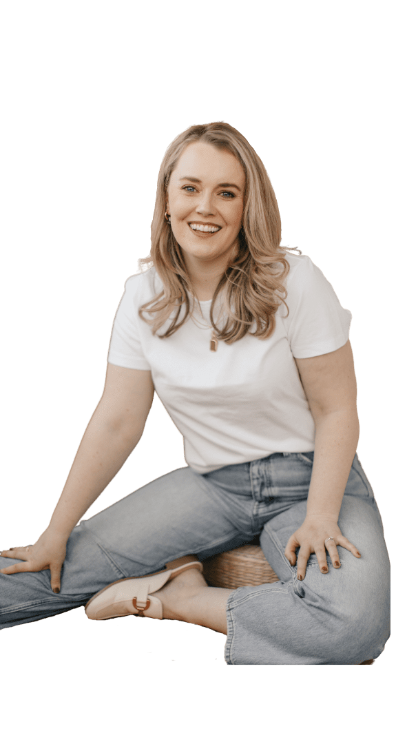 Alex Alexander smiling, sitting casually in jeans and white shirt, representing friendly connection and approachability.